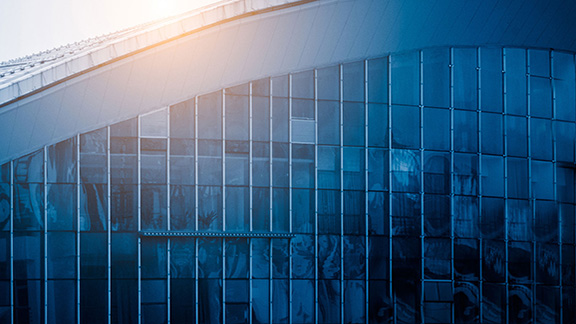 Close up of the sunlit edge of a commercial building with glass windows