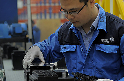 A person wearing glasses and gloves working on a machine.